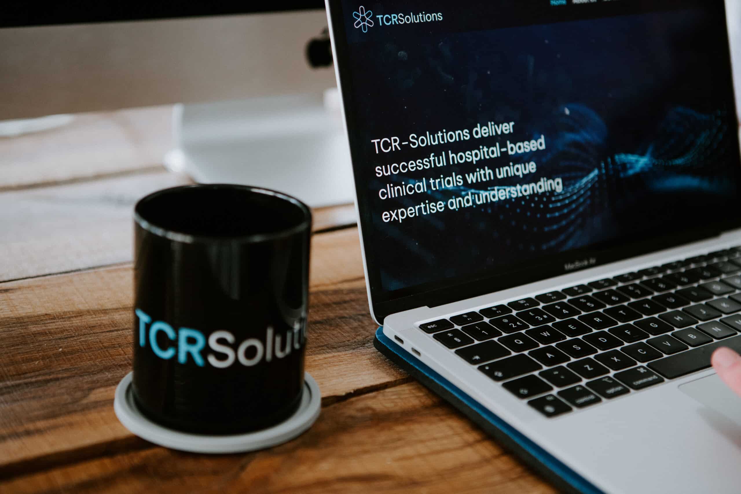 Laptop open showing the TCR- Solutions website