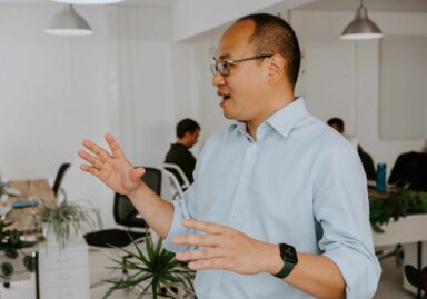 Man in blue shirt stood up addressing colleagues